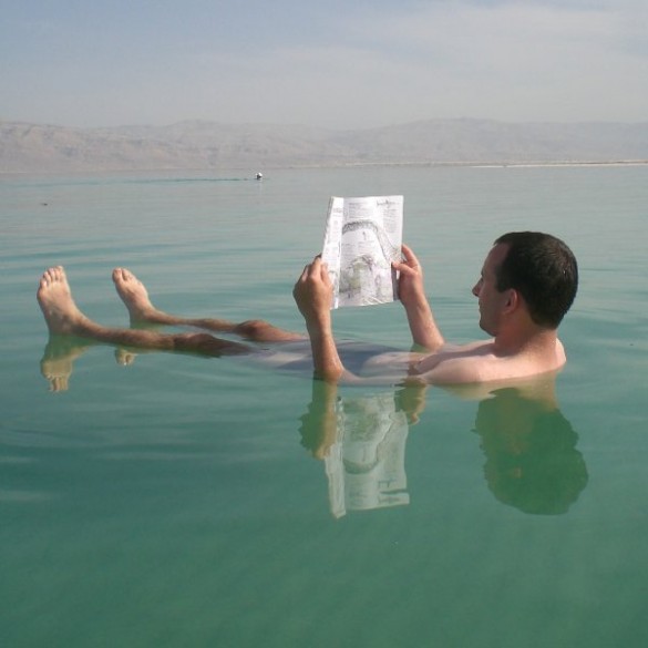 A man reads while floating in the Dead Sea, Ein Gedi, Israel A man reads while floating in the Dead Sea, Ein Gedi, Israel
